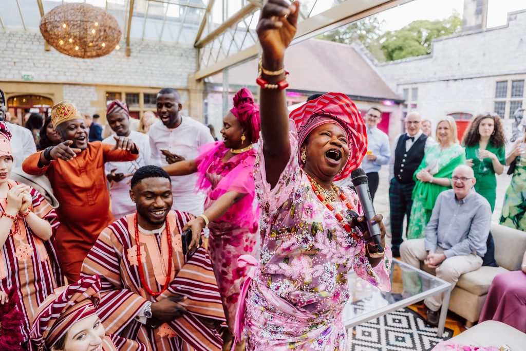 The Nigerian mother of the groom passionately performs a Nigerian tradition at a fusion wedding at Thornbridge Estate